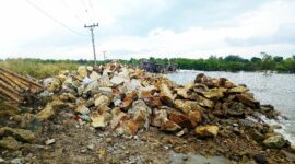 Bahan matreal berserak pada proyek Tanggul Pemecah Ombak Desa Bandar Rahmad. 