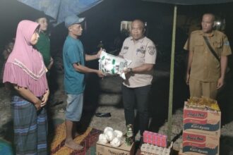 (Plt) Kepala Dinas Sosial Labuhanbatu, Syahrizal Hasibuan, SE saat menyalurkan bantuan kepada bapak Sumarno dilokasi kebakaran, Senin (20/03/2023) malam.