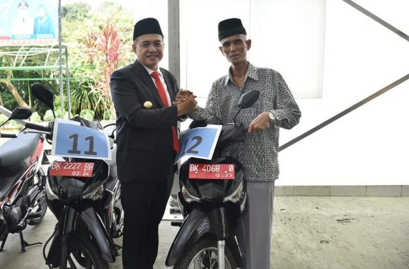 Bupati Batubara Zahir saat menyerahkan secara simbolis bantuan kendaraan dinas kepada Ketua MUI di Kabupaten Batubara