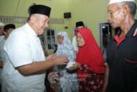 Bupati Asahan menyerahkan bantuan kepada masyarakat di Masjid Al-Iradah Pualau Bandring.(foto/Kominfoasahan).